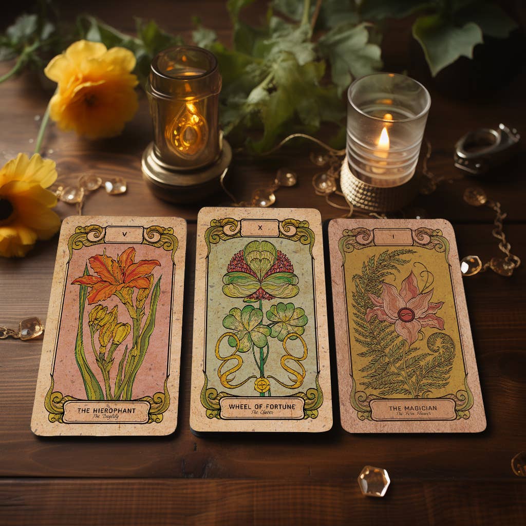 Three Botanica Oculta tarot cards with floral designs standing on a wooden tray