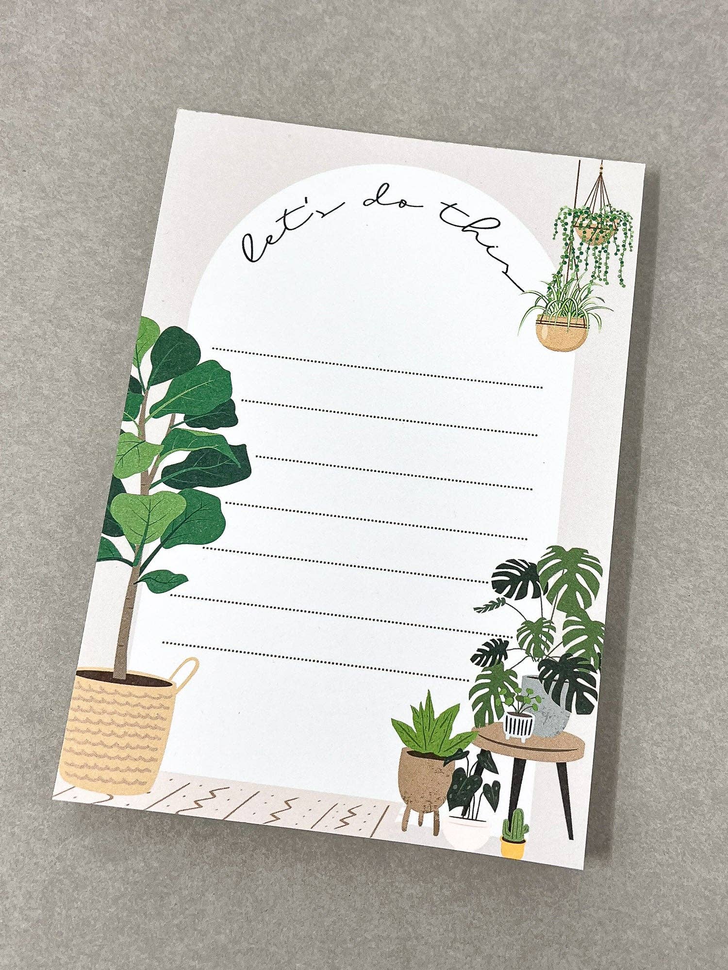 Home A6 notepad with "let's do this" header and potted plant illustrations lying flat